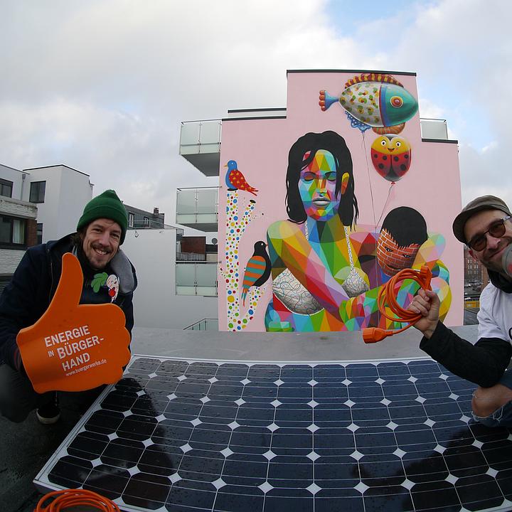 Zwei Personen neben einem kleinen PV-Panel